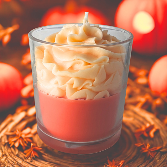 Candle in a glass container with wavy texture, surrounded by autumn leaves and pumpkins.