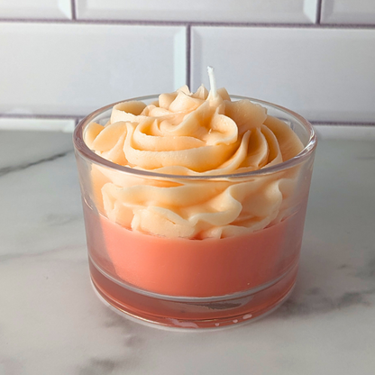 Candle in a glass container with a wavy design on a marble surface.