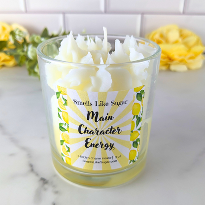 Candle in a glass jar with a label on a marble surface, featuring yellow flowers in the background.