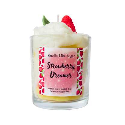 Candle labeled 'Strawberry Dreamer' with a pink label featuring strawberries on a white background.