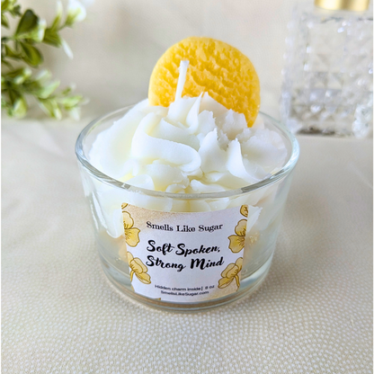 Candle in a glass jar with a decorative top, featuring a label on a neutral background.
